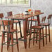 A Lancaster Table & Seating live edge table with chairs and wine glasses.