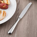 A Libbey stainless steel dinner knife on a plate of food.