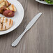 A plate of food with a Libbey stainless steel dinner knife.