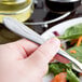 A person holding a Libbey stainless steel salad fork over a plate of salad.
