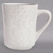 A white Tuxton china mug with black specks on it.