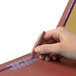 A person's hand holding a purple Smead SafeSHIELD folder.