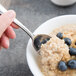 A Libbey stainless steel teaspoon holding a bowl of oatmeal with blueberries.
