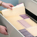 A person opening a file drawer filled with Smead file folders.