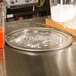 An American Metalcraft Super Perforated Wide Rim Pizza Pan on a counter with flour.