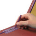 A person's hand holding a purple Smead classification folder with a pen.