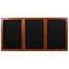 A black rectangular Aarco message board with a cherry wooden frame and three black felt doors.