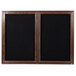 A black framed wooden cabinet with black felt message board doors.