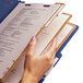A hand holding a Smead SafeSHIELD letter size classification folder with papers in it.