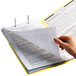 A person's hand holding a yellow Smead Shelf-Master folder with papers inside.
