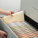 A hand opening a file drawer with Smead file folders inside.