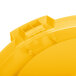 A yellow plastic lid for a Carlisle Bronco trash can with a small hole in the middle.
