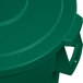 A Carlisle green plastic trash can lid on a green plastic trash can.