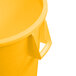 A close up of a yellow Carlisle Bronco trash can with handles.