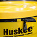 A yellow Continental Huskee round trash can with a yellow lid.