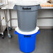 A stack of blue Continental Huskee trash cans with white lids.
