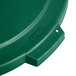 A green Carlisle Bronco round flat plastic trash can lid with holes.