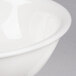 A close-up of a CAC Garden State bone white porcelain bowl with a rim.