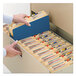 A hand opening a file drawer with blue Smead file folders inside.