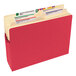 A close-up of a red Smead file folder with a label on the tab.