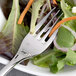 A Chef & Sommelier stainless steel salad fork spearing a carrot on a plate of salad.