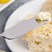 A Chef & Sommelier stainless steel butter spreader with butter on it.