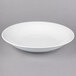 A 10 Strawberry Street Whittier white porcelain coupe bowl on a gray surface.
