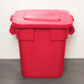A red Rubbermaid BRUTE trash can with a lid.