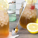 A Chef & Sommelier stainless steel iced tea spoon in a jar of lemonade with ice and lemons.