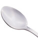 A close-up of a Libbey stainless steel teaspoon with a white handle.
