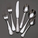 A group of Libbey stainless steel forks on a black surface.