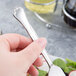 A person holding a Libbey Lady Astor stainless steel salad fork with salad on it.