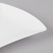 A Schonwald white porcelain bowtie tray with curved corners on a gray surface.