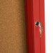 A red Aarco bulletin board cabinet with a key in the lock.