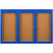 A brown board with a blue frame and three blue doors with glass panels.