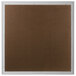 A brown square bulletin board with a white frame.