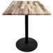 A Holland Bar Stool rustic wood table with a round black base.