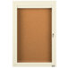 A white enclosed bulletin board cabinet with a brown door.