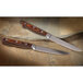 Two Chef & Sommelier steak knives with wooden handles on a stone surface.