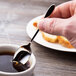 A Chef & Sommelier stainless steel demitasse spoon in a cup of coffee.