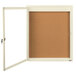 An ivory enclosed bulletin board with a cork board inside and a glass door.