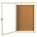 A white framed notice board with a cork board and a white door.