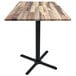 A Holland Bar Stool rustic wood laminate bar height table with a black cross base.