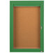 An Aarco green enclosed bulletin board cabinet with a cork board and a green door with a key.
