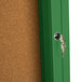 A green cork bulletin board inside a cabinet with a key in the lock.