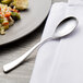 A Chef & Sommelier stainless steel teaspoon on a plate.
