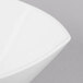 A close up of a Schonwald white square bowl with a curved edge.
