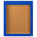 A blue framed bulletin board with a glass door and key.