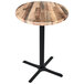 A round wooden table with a black cross base.