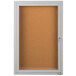 A white enclosed bulletin board cabinet with a satin anodized door.